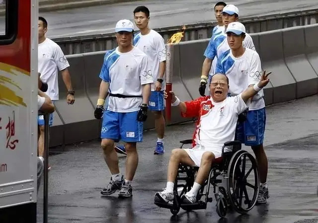 2008年，香港，行动不便的曾宪梓坐着轮椅完成了奥运火炬的传递，高呼“中国加油 ...