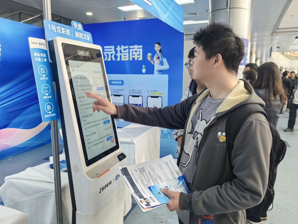 求职者在吉林省2024年高校毕业生公益招聘大会上了解招聘信息