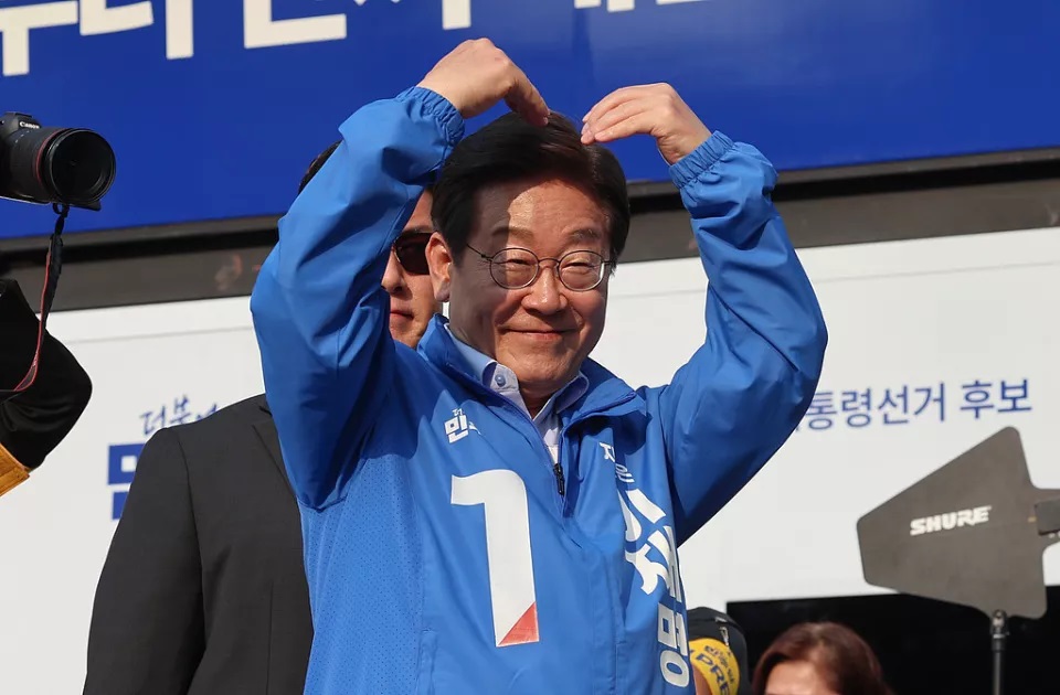 民主党总统候选人李在明在原州幸福广场举行的竞选活动中做心形手势